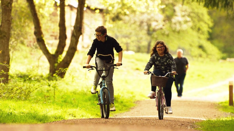 Children cycling on the Explorer Trail in Comer Woods at Dudmaston, Midlands